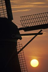 Silhouette of a windmill with laying down sun Holland