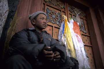 Young Tibetan in front of the door of a Buddhist temple China