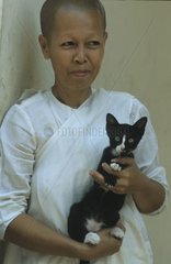 Nonne trägt ein Kätzchen in seinen Armen Kampuchea