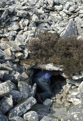 Man at the entrance of a burial chamber Scotland