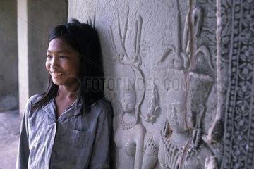 Young girl near an absarah in Angkor Vat in Cambodia