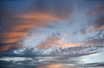 Orange and grey clouds in blue sky France