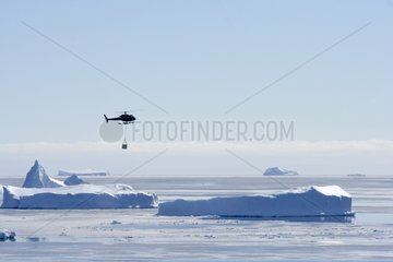 Helicopter over the sea ice and icebergs Adelie Land