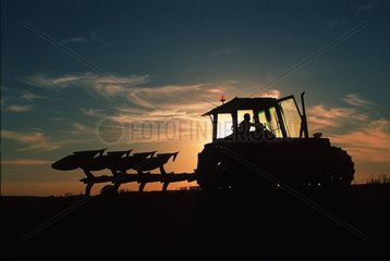 Labour avec charrue réversible au coucher de soleil France