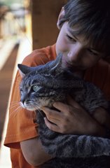 Young boy holding his cat in his arms France