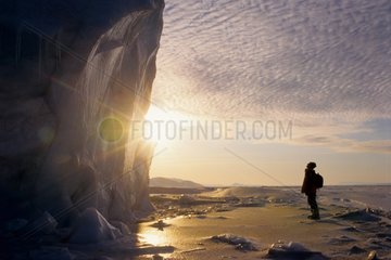 Man vis-a-vis the face of glacier to the midnight sun Arctic