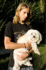 Young man carrying a Tulear cotton dog