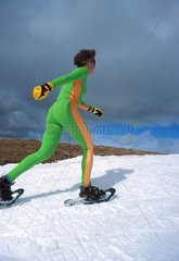 Femme marchant dans la neige avec des raquettes Andorre