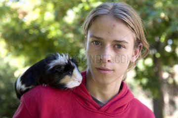 Teenager carrying a Guinea pig on his shoulder