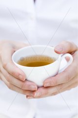 Hands of a woman holding a cup of tea