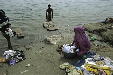Woman washing clothes on the bank of the river India