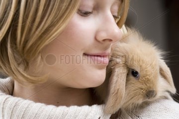 Girl with a young rabbit ram on the shoulder France