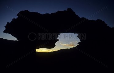 Fenêtre naturelle dans la roche et coucher de soleil