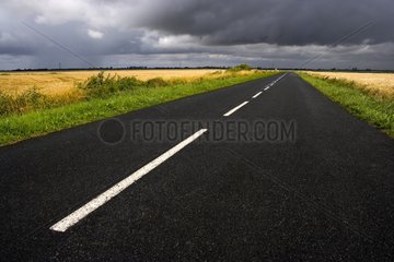 Campaign road under a cloudy sky France