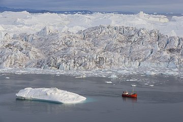 Touristenboot vor dem großen Eisberg um Mitternacht Grönland