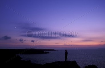 Person observing the crescent moon and the Ocean France