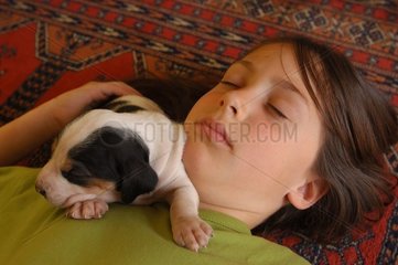 Fillette endormie avec son chiot