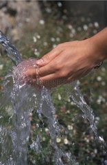 Hände unter Wasser fließen aus einem Brunnen Frankreich