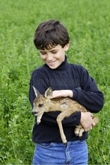 Junge mit einem Kitz aus Roe-deer Elsass Frankreich