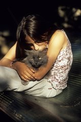 Young girl cuddling a cat on her knees