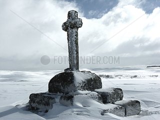 Landschaft und Kreuz unter dem Schnee im Winter Aubrac