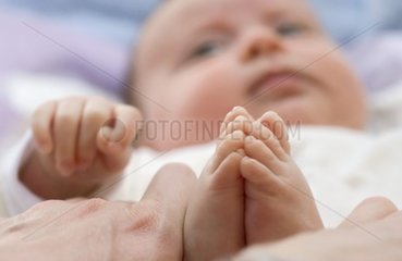 Baby spielt mit seinen Füßen Frankreich