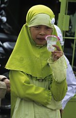 Young girl with traditionnal clothes drinking Java