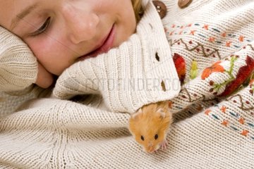 Girl with an outgoing gilded hamster of the collar of its sweater