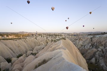 Hot air ballons landing over an eroded valley Turkey
