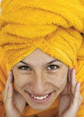 Woman applying cream on her face skin after bath