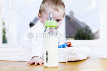 Baby old of 8 months near a nursing bottle without Bisphenol