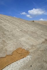 Bulldozer leveling a mine dump made with coconut geotextile