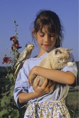 Portrait of a young girl with kitten and Cockatiel