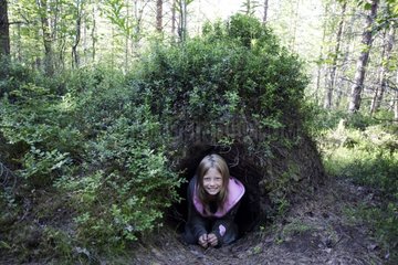 Mädchen mit Knien beim Eintritt einer Höhle von Brownbär Finnland