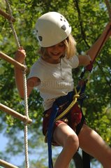Young girl on a rope ladder in Tree climbing
