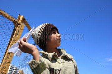 Boy throwing a paper airplane in the sky over Beirut Lebanon
