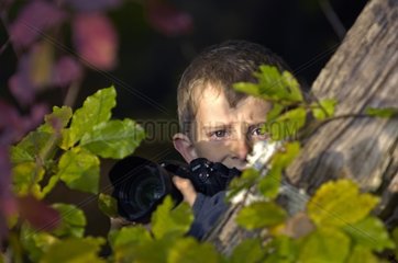 Portrait of a young Boy with his camera in forest