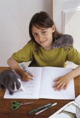 Fille faisant ses devoirs avec lapin nain et cobaye