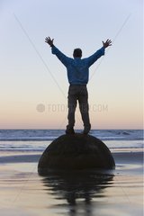 Man standing on Moeraki Boulder South Island New Zealand