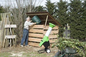 Man tipping garden waste into a composting bin Provence