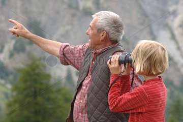 Grandfather helping her granddaughter to observe nature