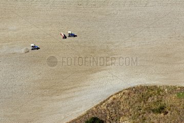Caterpillar tractors in sloping fields in Tuscany
