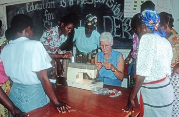 Woman aid worker teaching women's sewing class Malawi