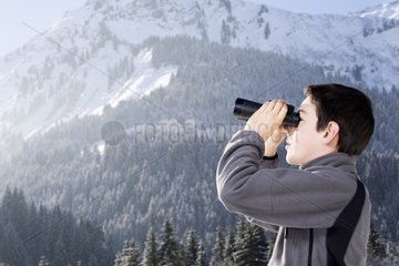 Young boy and binoculars in the mountains in winter