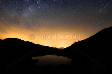 First light of dawn on the lake of the fairies  the stars are still visible  as well as a shooting star  Massif du Beaufortain  Savoie  Alps  France