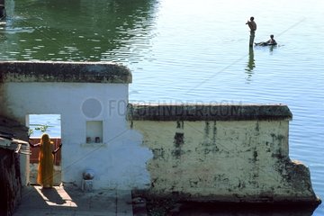Woman watching children play on the lake Udaipur India