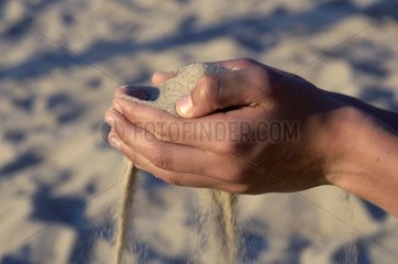 Sand  der durch die Hände des Kindes passt