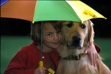 Fillette et Golden Retriever sous un parapluie