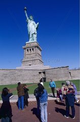 New York; groupe de touristes devant la Statue de la Liberté