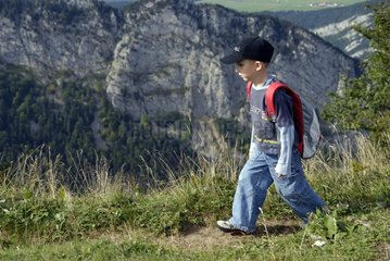 Boy walking on the cliffs of Creux-du-Van Jura Switzerland